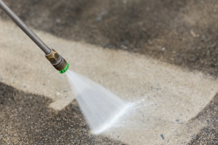 Pressure washer cleaning dirt of concrete