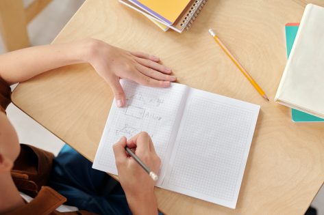 Clean classroom and student taking notes in notebook